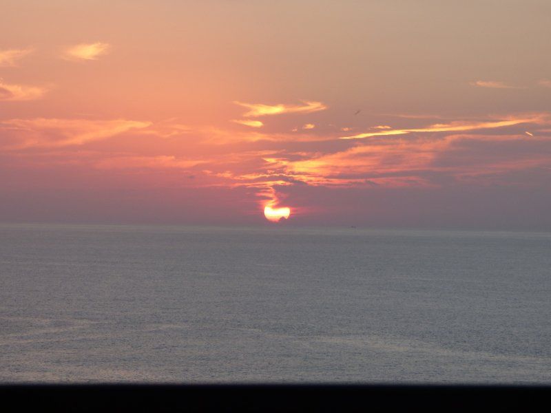 The sun is setting over the ocean.