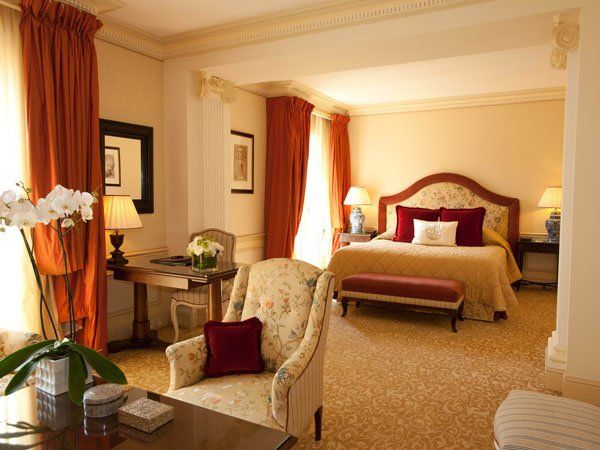 A hotel room with a large bed and chairs