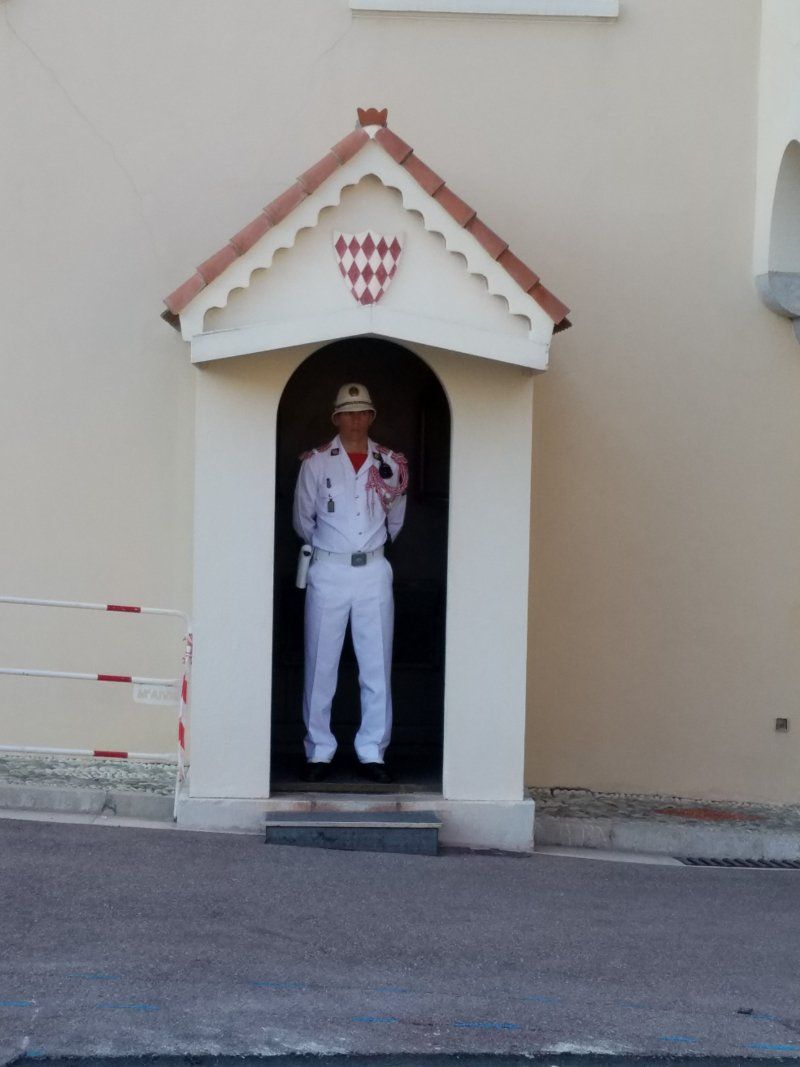 A man in a white uniform is standing in a doorway