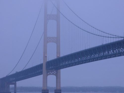 A bridge over a body of water on a foggy day
