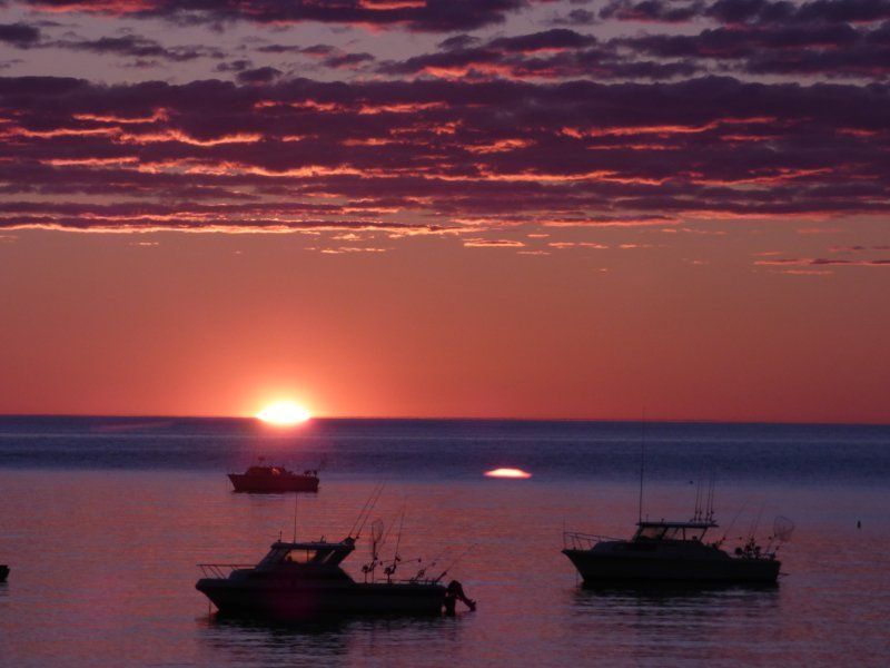 A sunset over the ocean with boats in the water