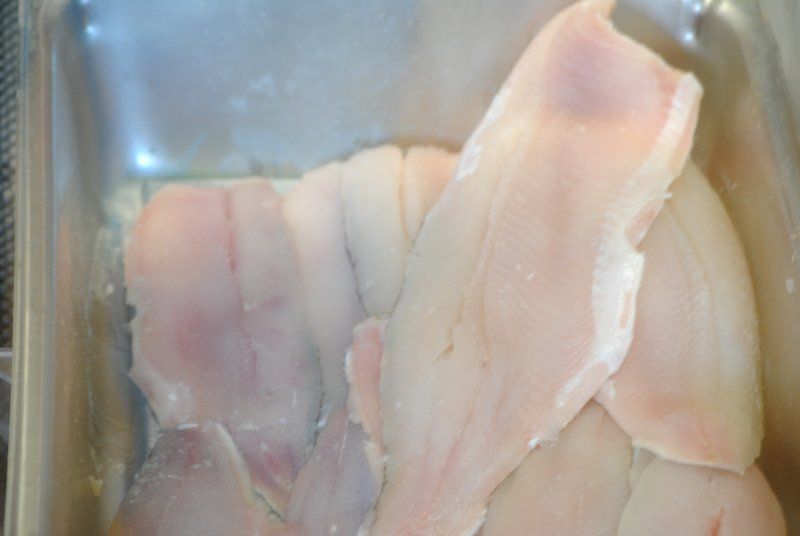 A close up of a plastic container filled with chicken breasts.