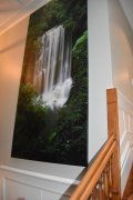 There is a picture of a waterfall on the wall next to a staircase.