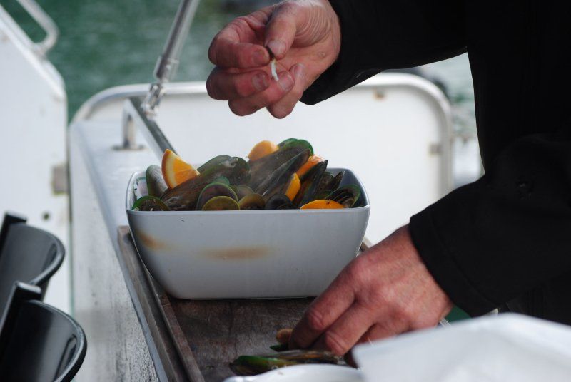 A person is preparing food in a white bowl on a boat
