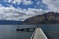 A pier leading into a body of water with mountains in the background.