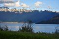 A lake with mountains in the background and grass in the foreground.