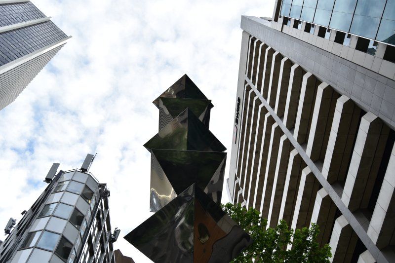 Looking up at a sculpture in the middle of a city