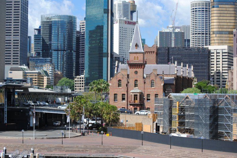 A large building with a clock tower in the middle of a city