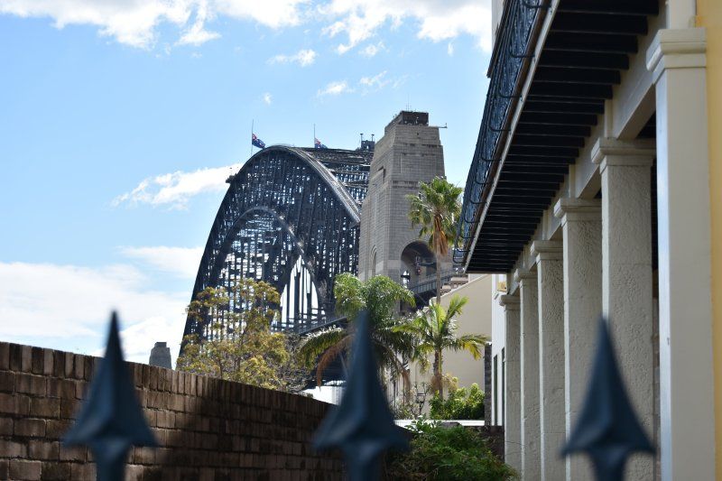 A bridge is visible behind a building with a fence in the foreground.