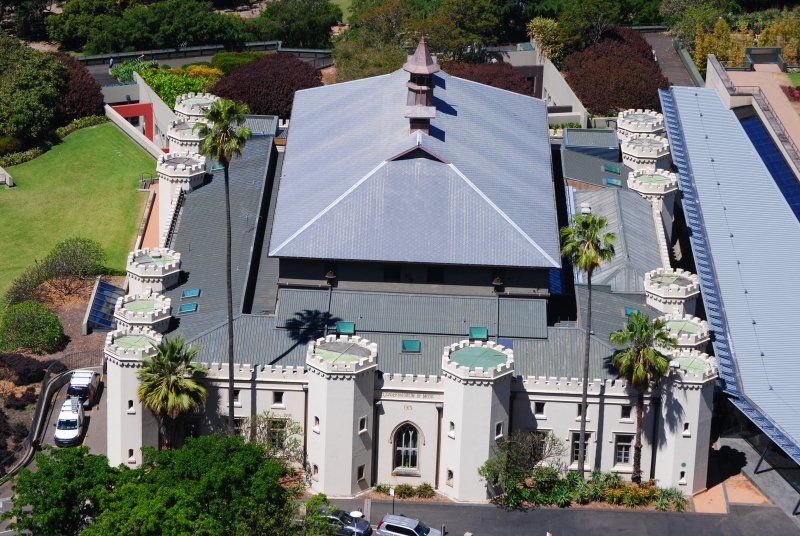 An aerial view of a large building with palm trees in front of it