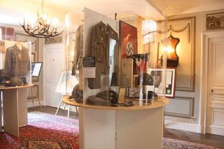 A room with a lot of clothes on display in a museum.
