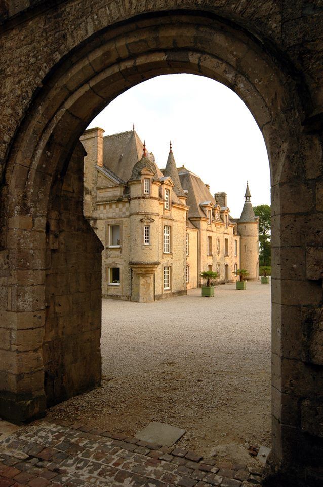 A view of a castle through a stone archway