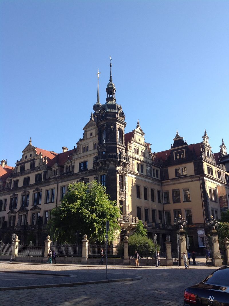 A car is parked in front of a large building