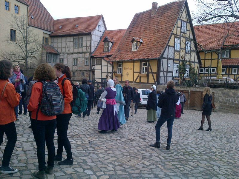 A group of people standing in front of a row of houses
