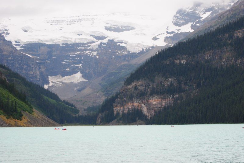 A lake surrounded by mountains and trees with a mountain in the background