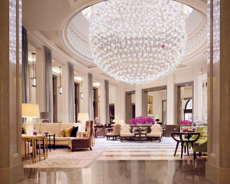 A hotel lobby with a large chandelier hanging from the ceiling