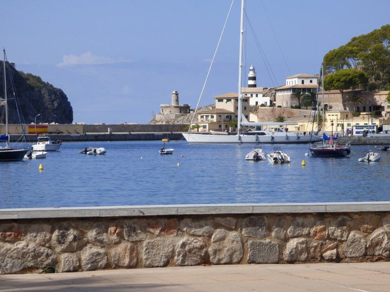 A harbor with boats and a lighthouse in the background