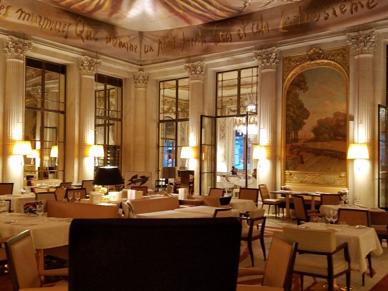 A large room with tables and chairs and a laptop on a table