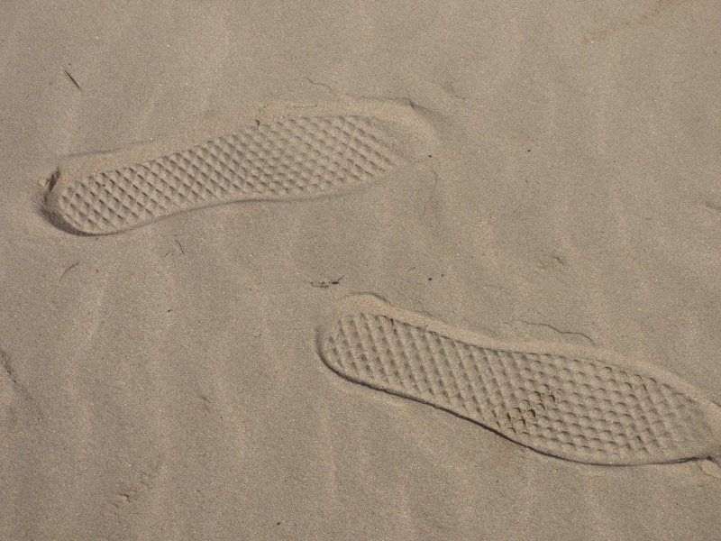 A pair of footprints in the sand on a beach