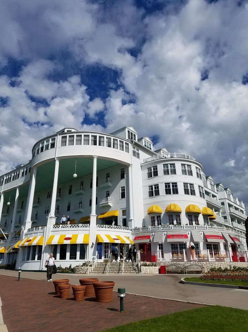 A large white building with yellow awnings and a blue sky in the background.