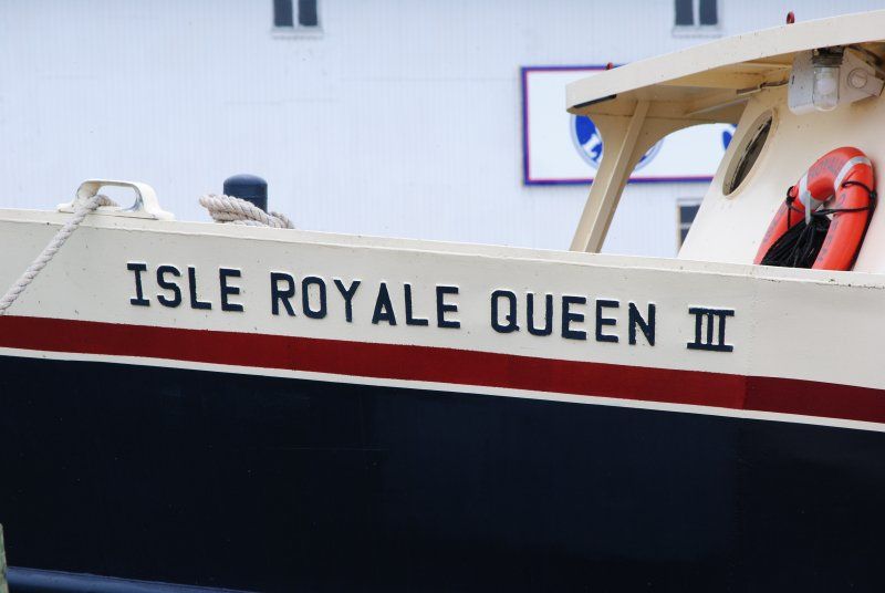 A boat with the name isle royale queen iii on the side