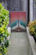 A painting on a wall next to a fountain in a garden.