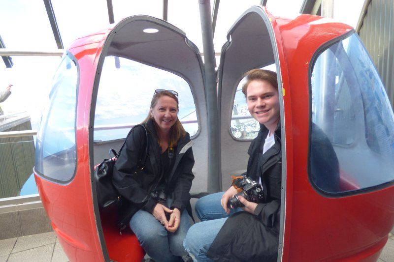 A man and a woman are sitting in a red gondola