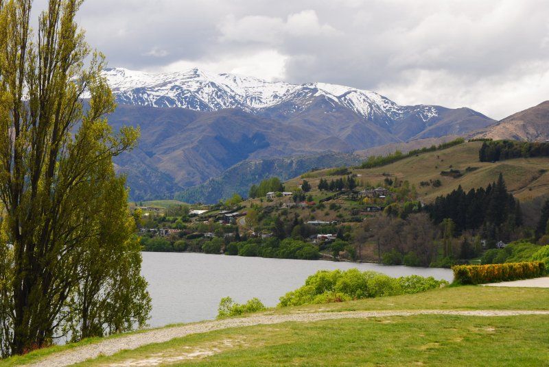 A lake with snow covered mountains in the background