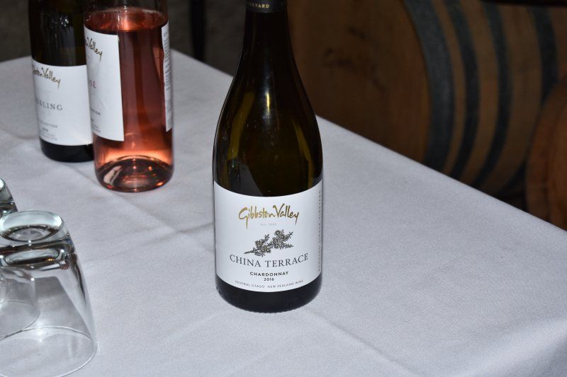 A bottle of wine is sitting on a table next to a glass