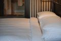 A bed with white sheets and pillows in a hotel room.