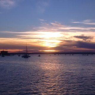 A sunset over a body of water with boats in it