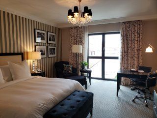 A hotel room with a large bed and a desk