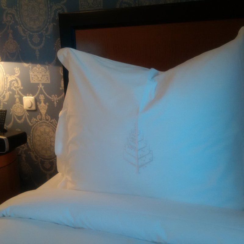 A bed with white sheets and a white pillow