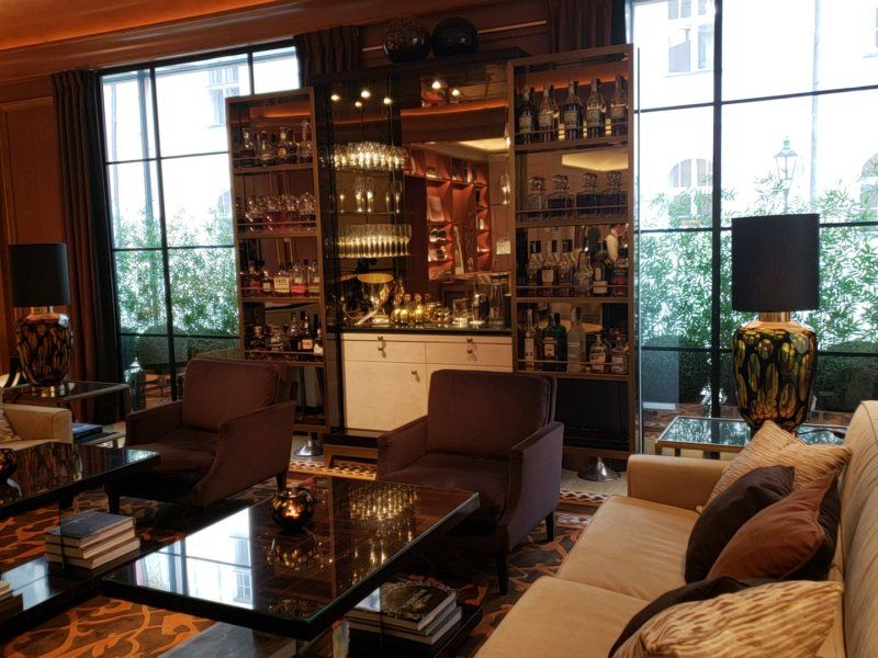 A living room with a couch , chairs , tables and a bar.