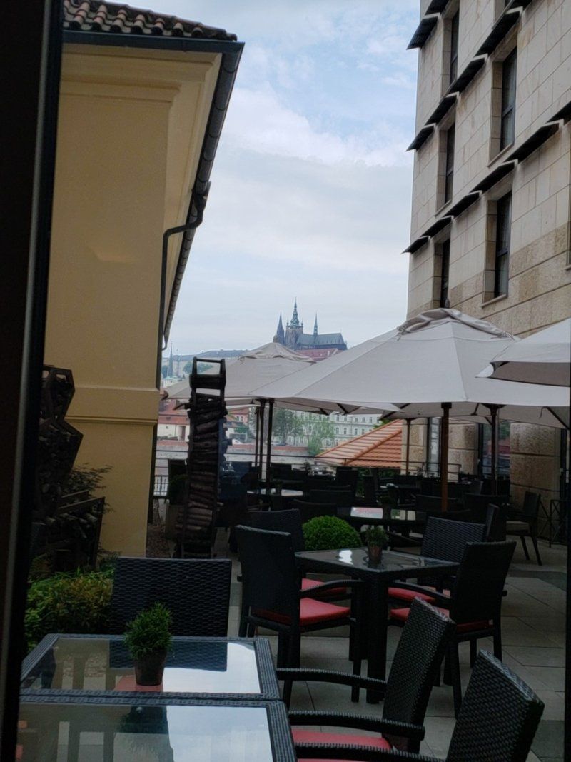 A patio with tables and chairs and umbrellas in front of a building