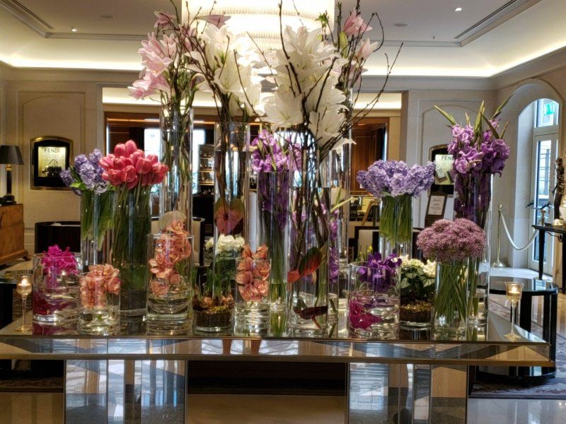 A table with lots of vases of flowers on it
