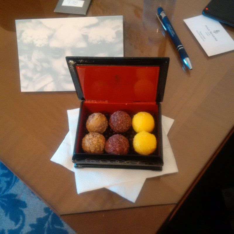 A box of four different colored balls sits on a napkin on a table