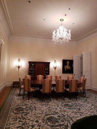 A large dining room with a table and chairs and a chandelier.