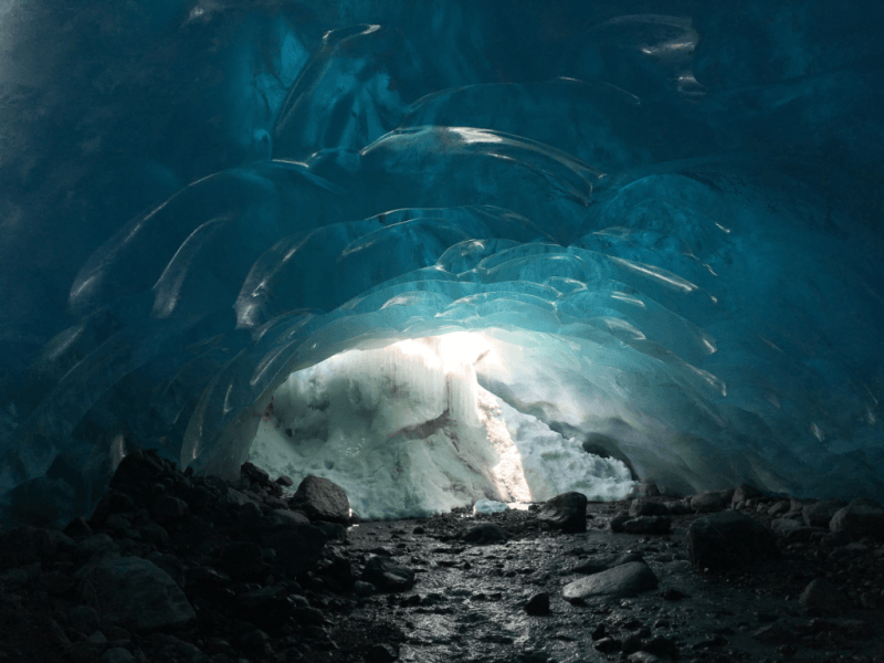 A polar bear is sleeping in an ice cave.