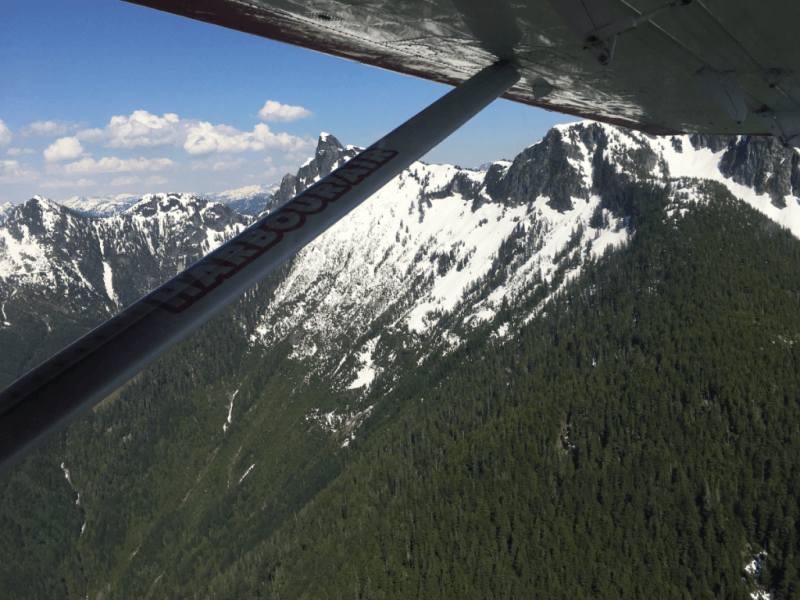 A plane is flying over a snowy mountain range