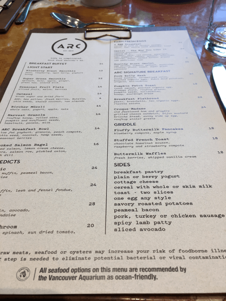 A menu for a restaurant is on a clipboard on a table.