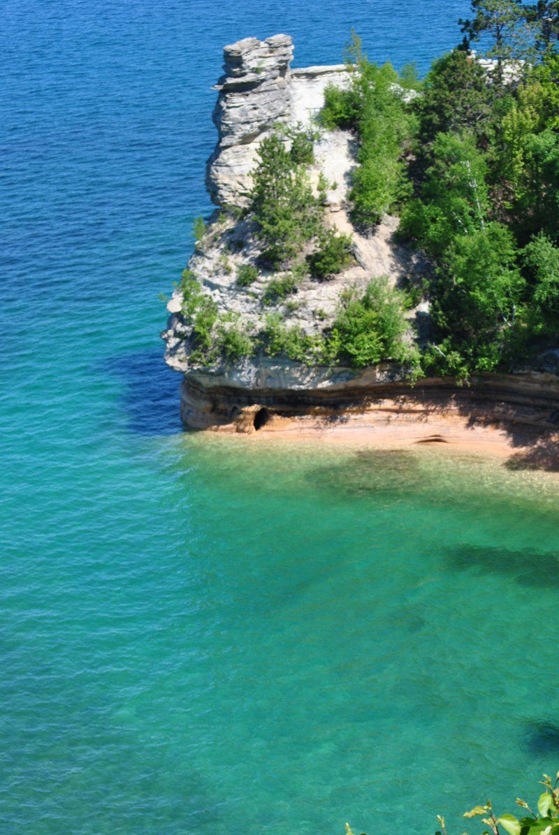 A large rock in the middle of a body of water