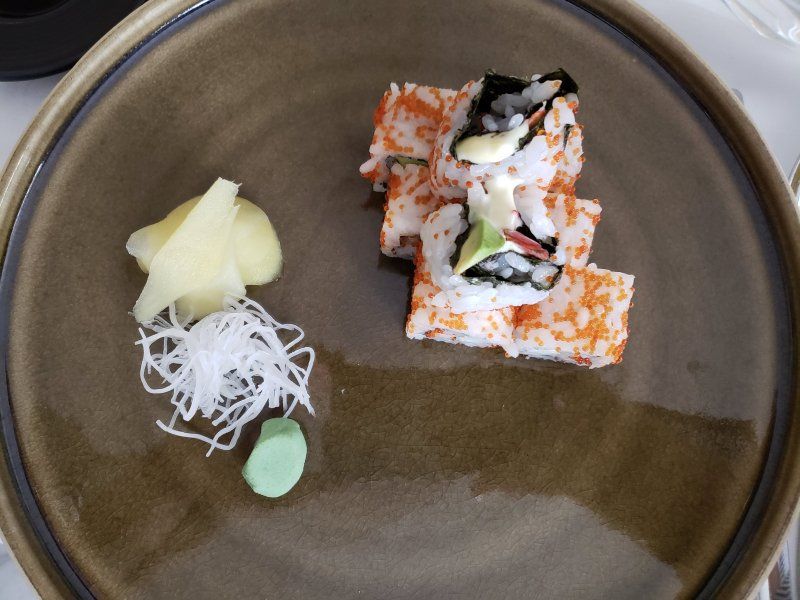 A plate of sushi with ginger and wasabi on it