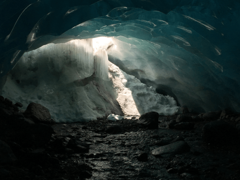 The sun is shining through the ice in a cave