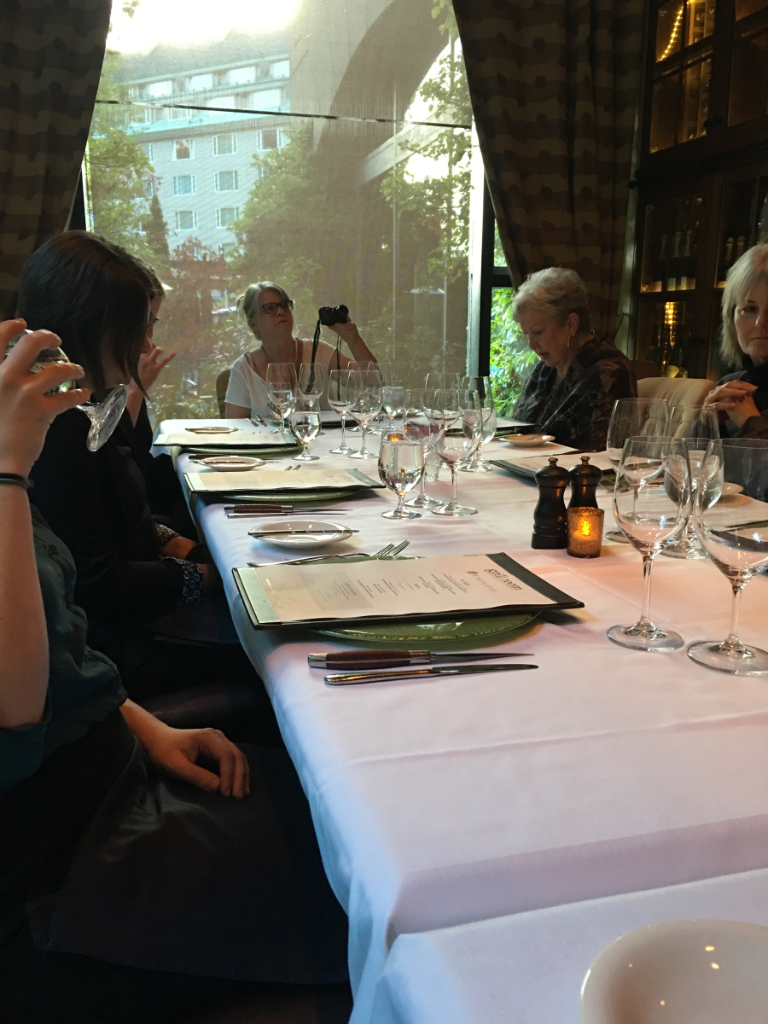 A group of people are sitting at a long table in a restaurant.