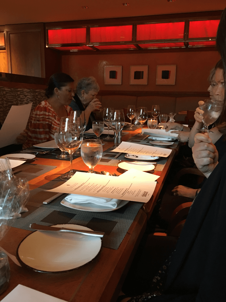 A group of people are sitting at a long table in a restaurant.
