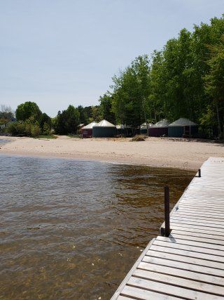 A wooden dock leads to a sandy beach