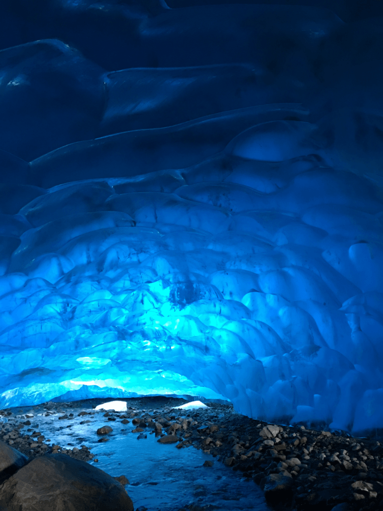 The inside of an ice cave with a river running through it