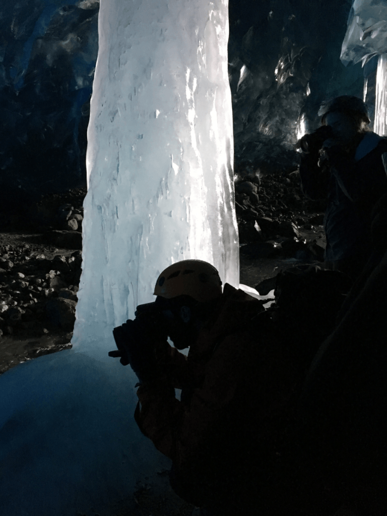 A man is taking a picture of an ice sculpture