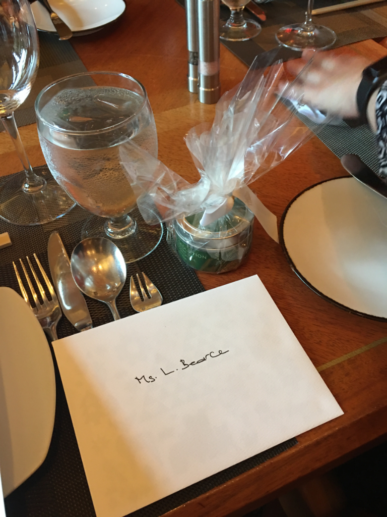 A place setting with a piece of paper that says mrs. i. beattie